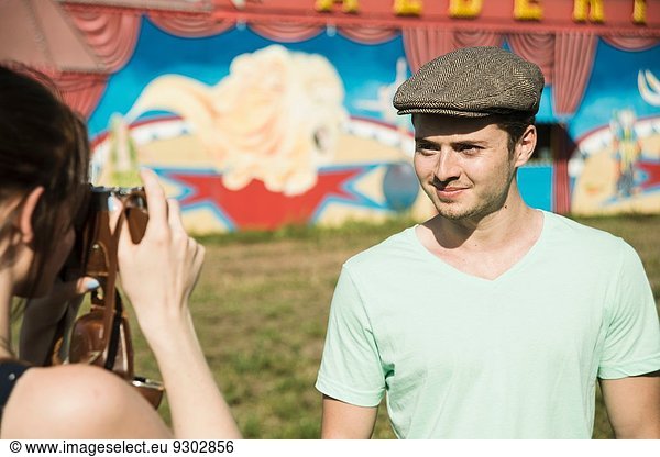 Young couple photographing on SLR camera at funfair