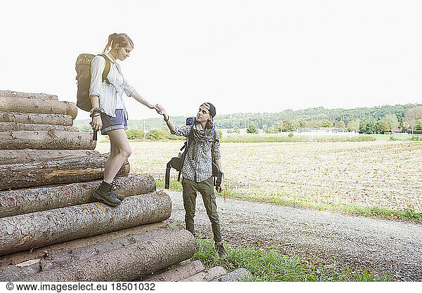 Young couple preparing to continue their hiking on wood pile  Bavaria  Germany