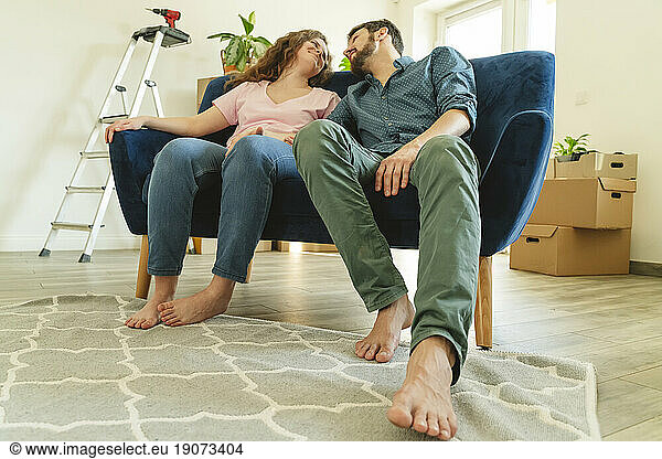 Young couple sitting on sofa in new home