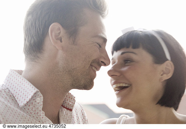 Young couple smiling face to face outdoors