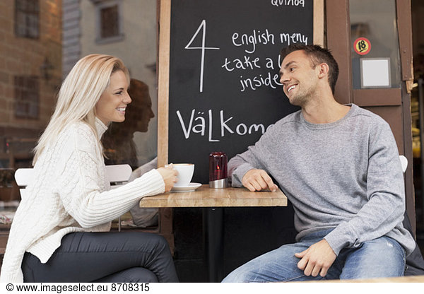 Young couple spending leisure time at outdoor cafe