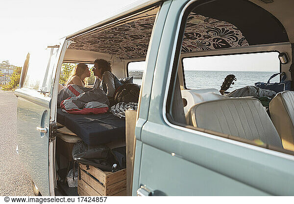 Young couple spending leisure time in van during vacation