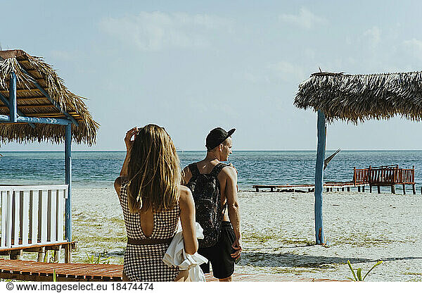 Young couple strolling at beach on sunny day