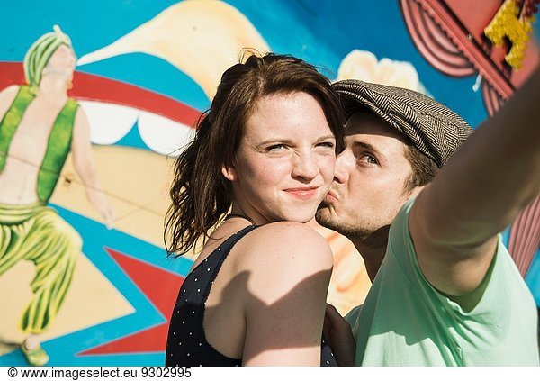 Young couple taking self portrait at funfair