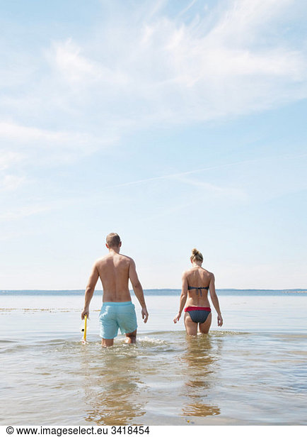 Young couple walking in the water