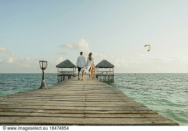 Young couple walking together on pier