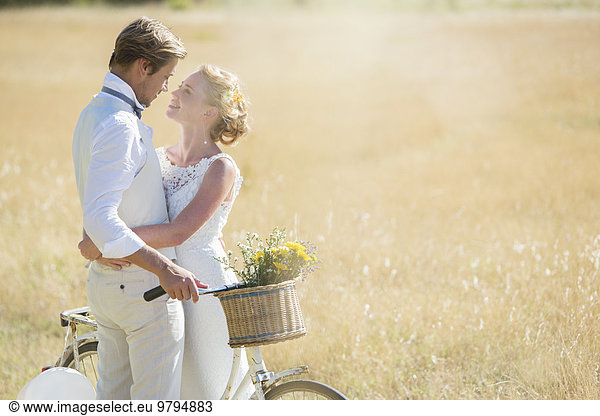 Young couple with bike in meadow