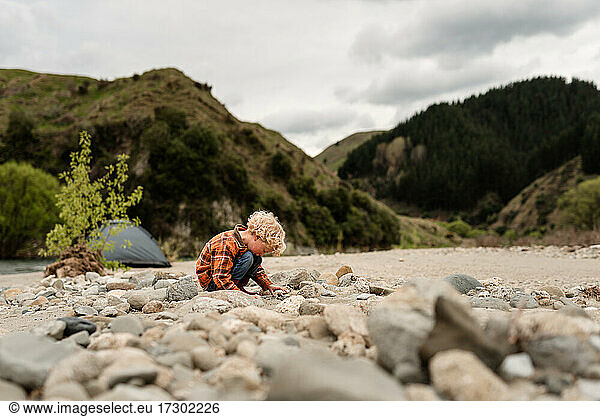 Young curly haired child looking at rock fossils in New Zealand