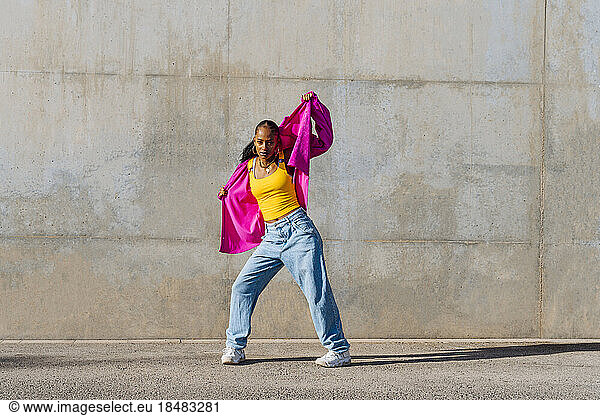 Young dancer breakdancing in front of wall