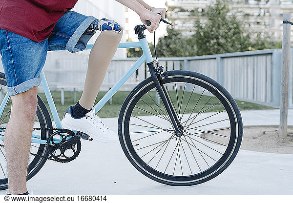 Young disabled cyclist riding bike in city