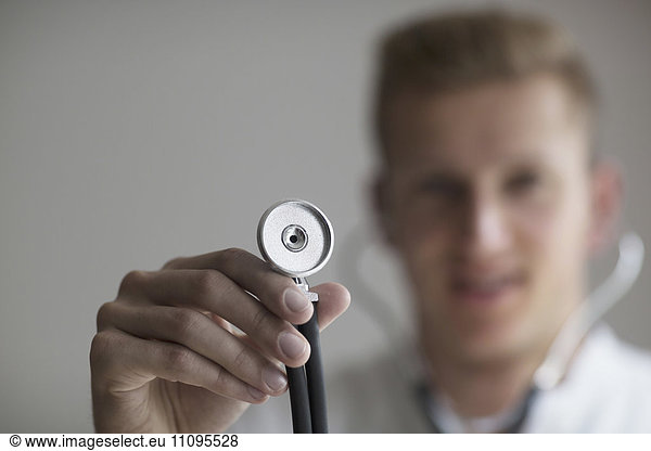 Young doctor holding stethoscope  Freiburg im Breisgau  Baden-Württemberg  Germany