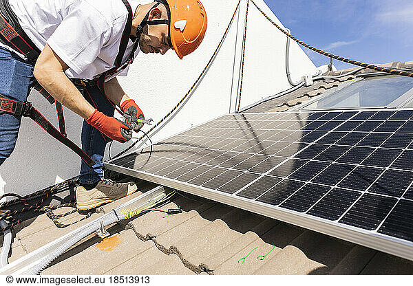 Young engineer with work tool installing solar panels