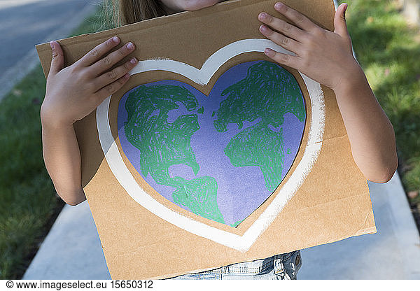 Young environmental activist holding sign