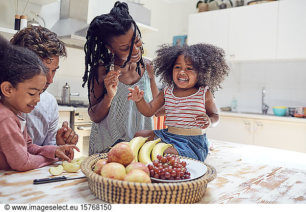 Young family eating fruit in kitchen