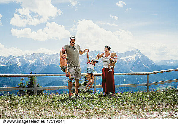 Young family having fun with kids in the Alps in summer