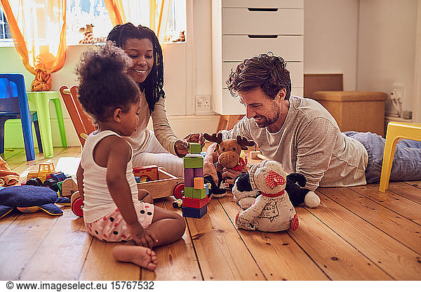 Young family playing with toys on floor