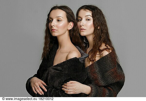 Young fashion twins. sister embosom her sister. perfect healthy skin. red lips