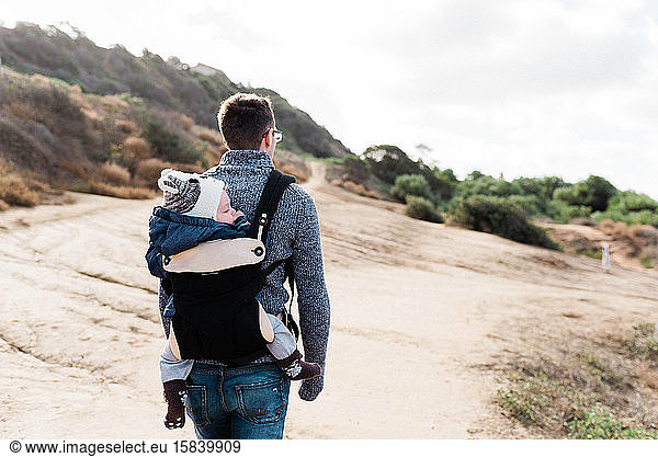 Young father hiking with his baby son in Southern California.