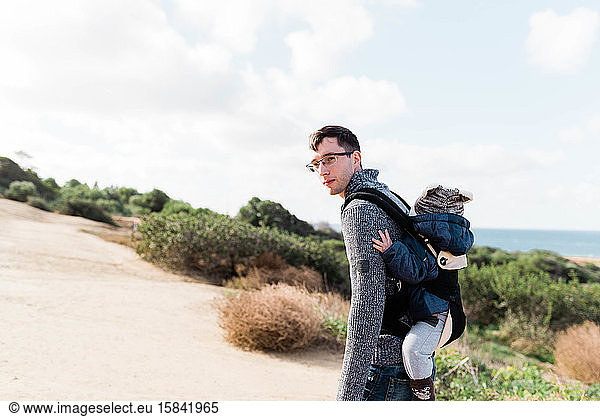 Young father hiking with his baby son in Southern California.