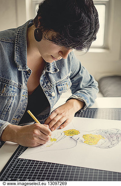 Young female artist drawing on paper