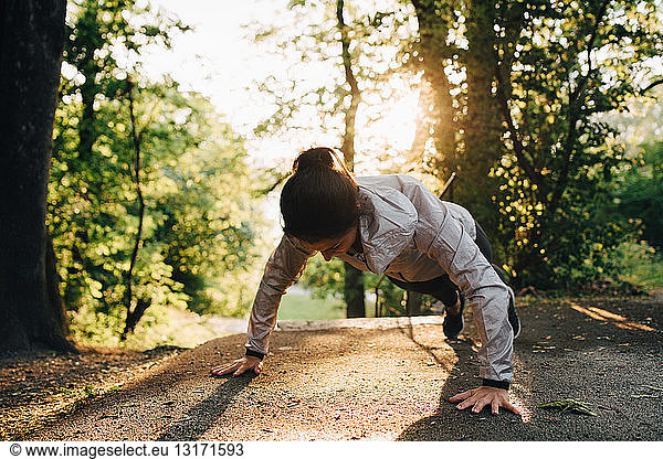 Young female athlete doing push-ups in park