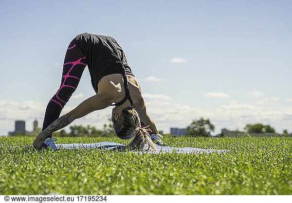 Young female athlete doing yoga and using her flexibility