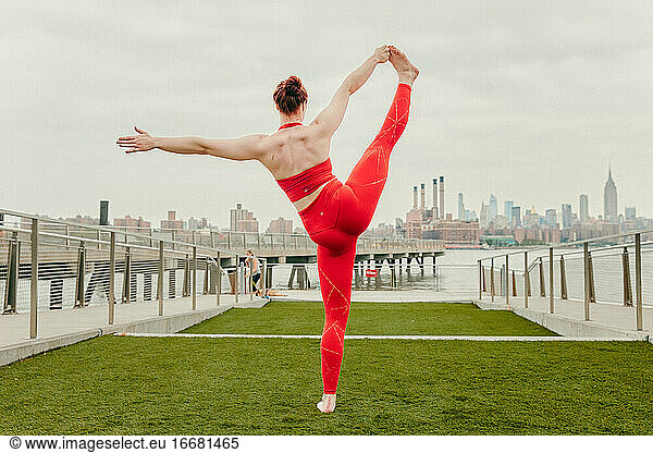 Young female athlete stretching by waterfront in Brooklyn  NY.