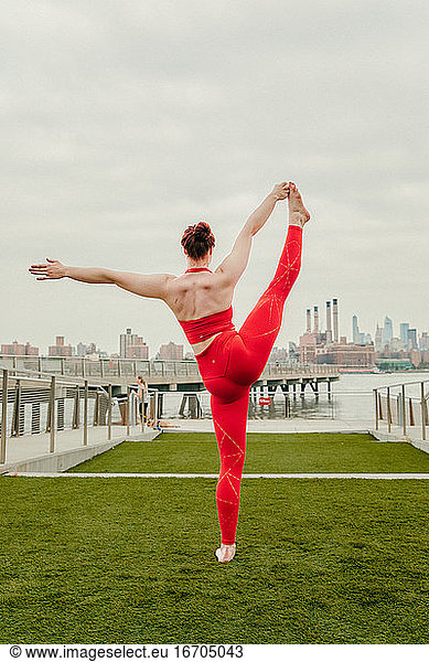 Young female athlete stretching by waterfront in Brooklyn  NY.