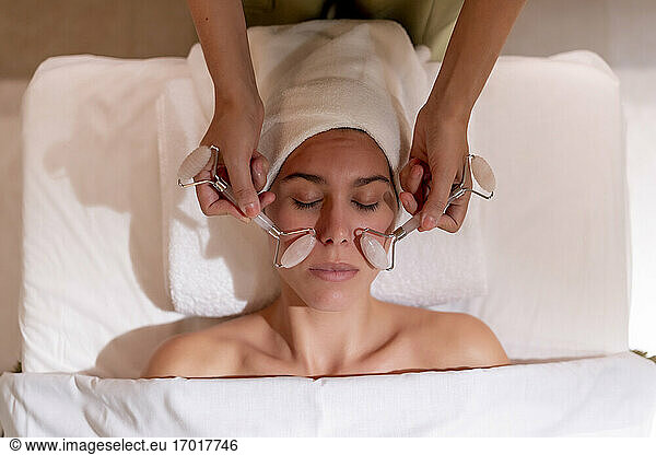 Young female customer receiving spa treatment from massage therapist