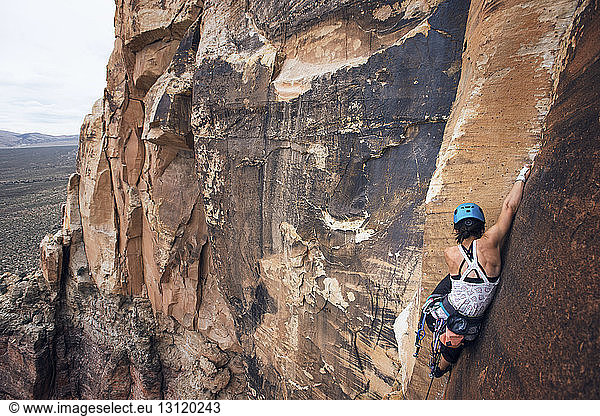 Young female hiker climbing rocky mountains at Red Rock Canyon National Conservation Area