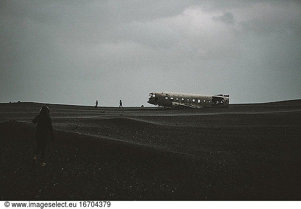 Young Female hiker walking towards famous Icelandic plane wreck
