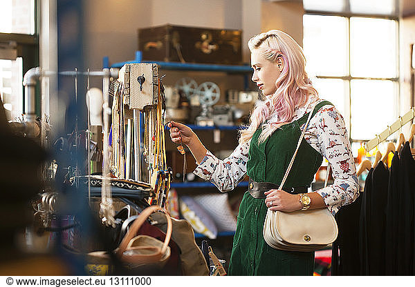 Young female looking at necklace in store
