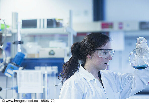 Young female scientist examining flask in a laboratory  Freiburg Im Breisgau  Baden-wuerttemberg  Germany