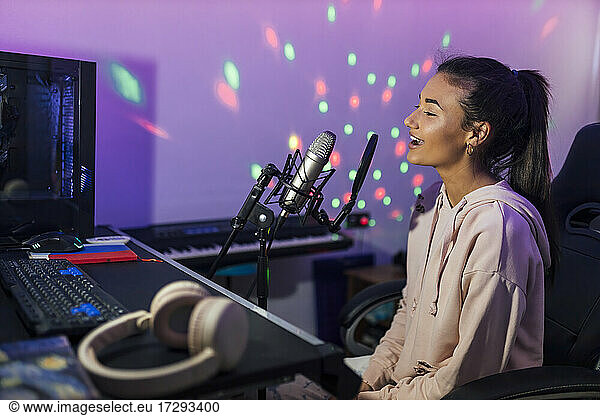 Young female singer singing in studio