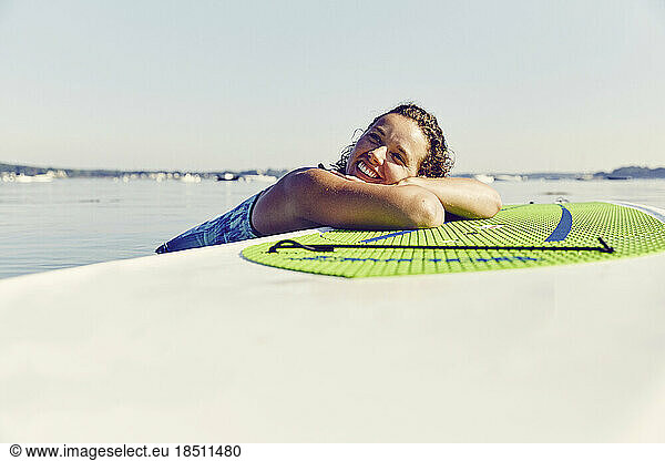 Young female smiles on standup paddle board in Casco Bay  Maine