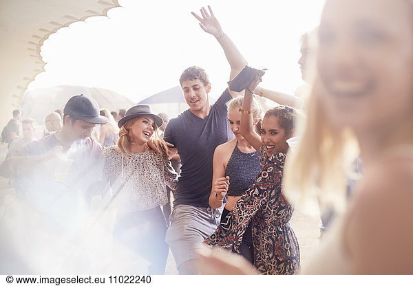 Young friends dancing at music festival