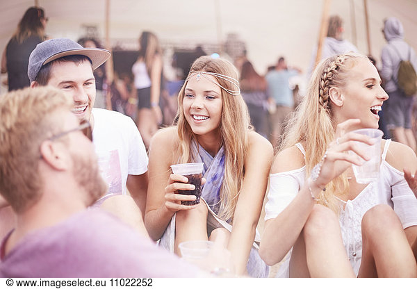 Young friends hanging out drinking at music festival