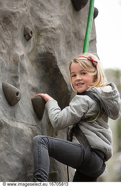Young Girl Climbing on a Climbing Wall