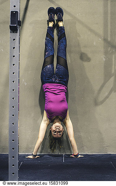 Young girl doing a handstand at a crossfit gym