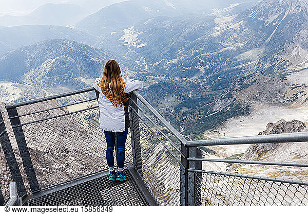 young girl enjoys the views of the Alps from the observation deck