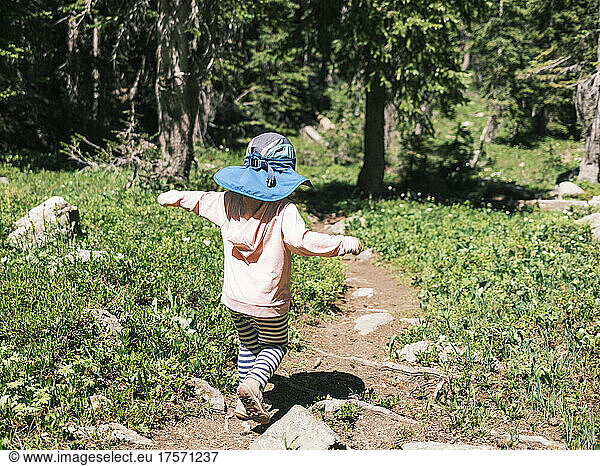 Young girl hiking down a trail  Colorado