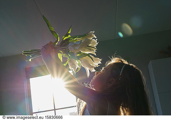 Young girl holding a bouquet from white tullips .