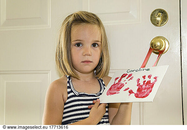 Young Girl Holding An Image Of Her Handprints; Ontario Canada
