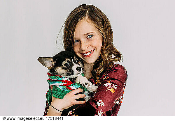 Young girl holding corgi puppy