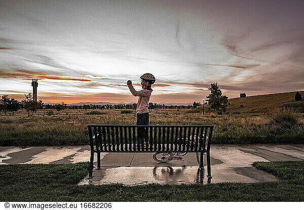 young girl holds a camera to take a photo in a neighborhood park