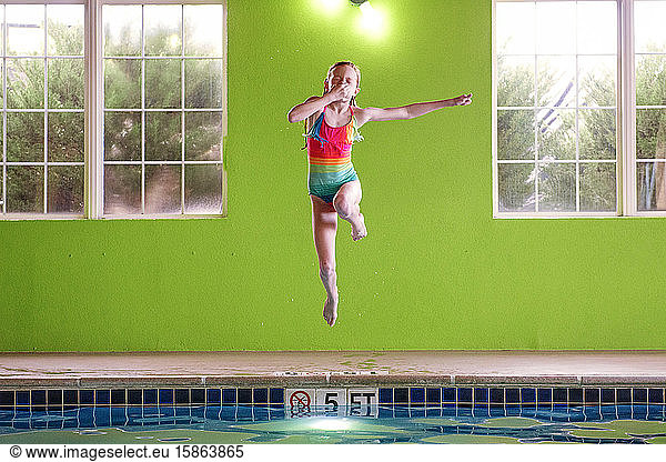 Young Girl Jumping in an indoor Swimming Pool