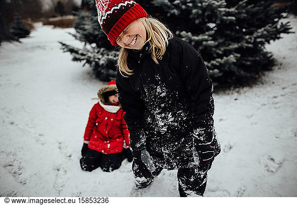 Young girl laughing while playing in the snow