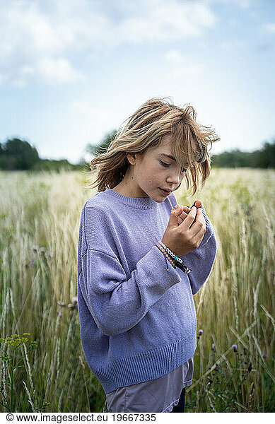 Young Girl Looking at Lady Bug in a Beautiful Field in Denmark