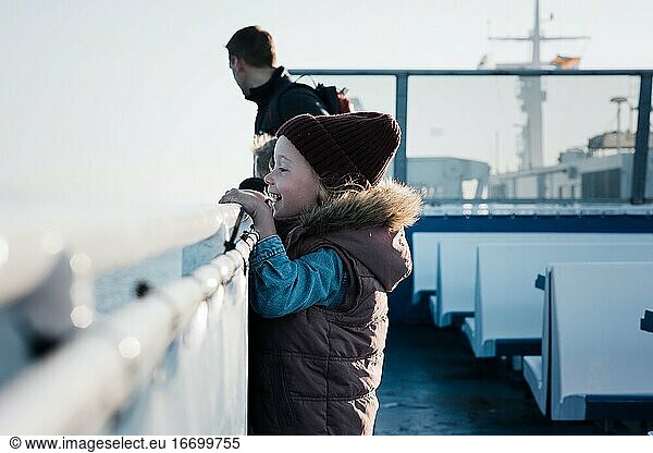young girl looking excited whilst travelling on a ferry boat