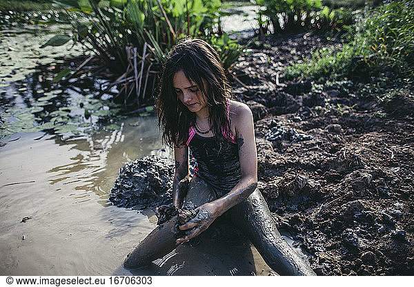 Young girl playing in the mud in Queensland Australia